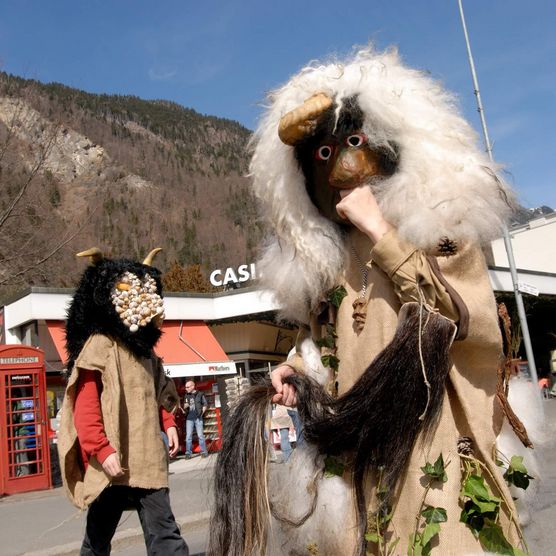 Zwei Maskierte laufen auf dem Höheweg anlässlich der Harder-Potschete in Interlaken