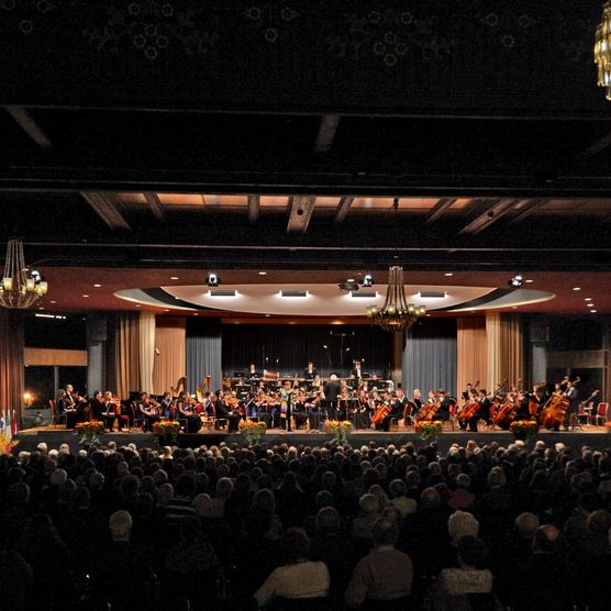 Zuschauer und Musiker in beleuchtetem Saal während der Interlaken Classics