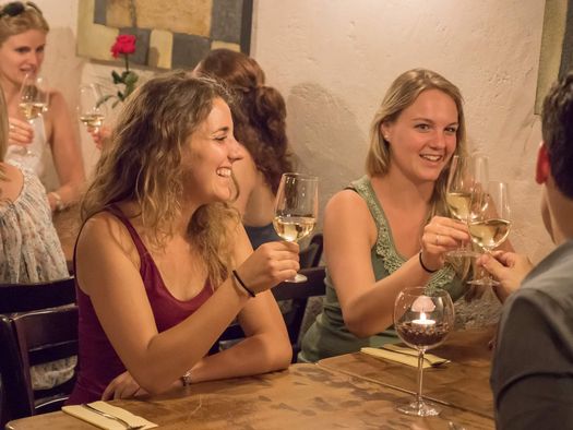 Zwei Frauen stossen mit einem Glas Wein während der Stadtführung kulinarisches Thun an