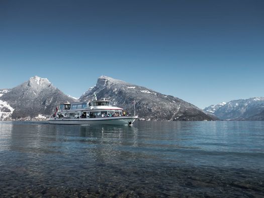 Schiff auf dem blauen Thunersee mit verschneitem Niederhorn im Hintergrund