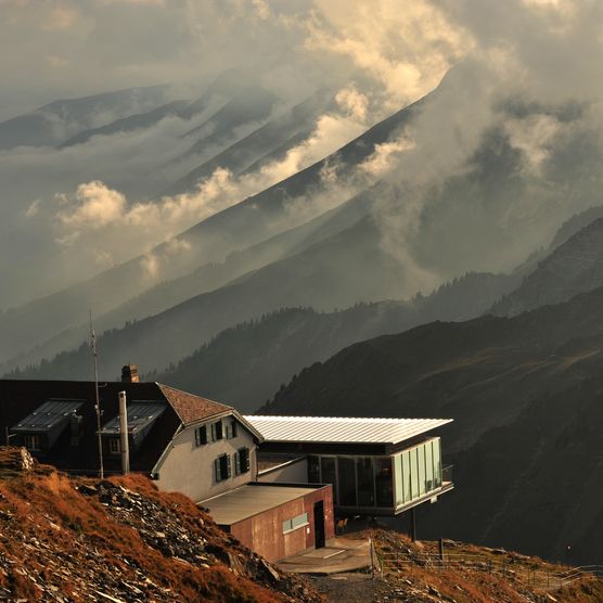 Blick auf das Berghaus Niesen Kulm umgeben von stimmungsvollen Wolken