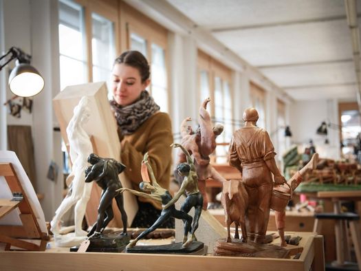 Schüler arbeiten in der Schnitzlerschule an hölzernen, handgemachten Skulpturen