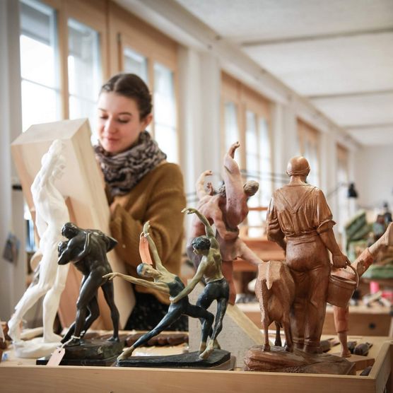 Schüler arbeiten in der Schnitzlerschule an hölzernen, handgemachten Skulpturen