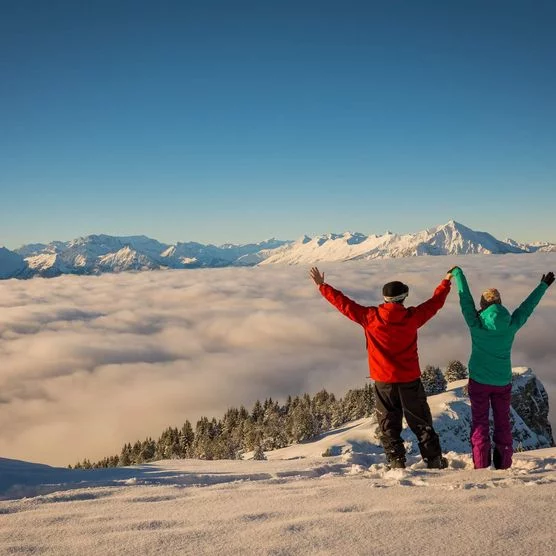 Zwei Wanderer blicken über das Nebelmeer auf dem verschneiten Niederhorn