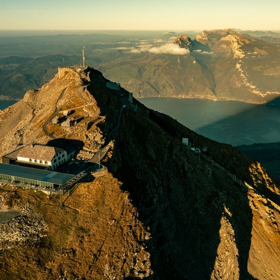 Luftaufnahme vom Niesen mit dem Berghaus und Blick auf den Thunersee