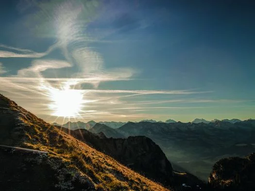 Die Sonne steht tief an den Berghängen des Stockhorns und taucht die Berglandschaft in goldenes Licht. 