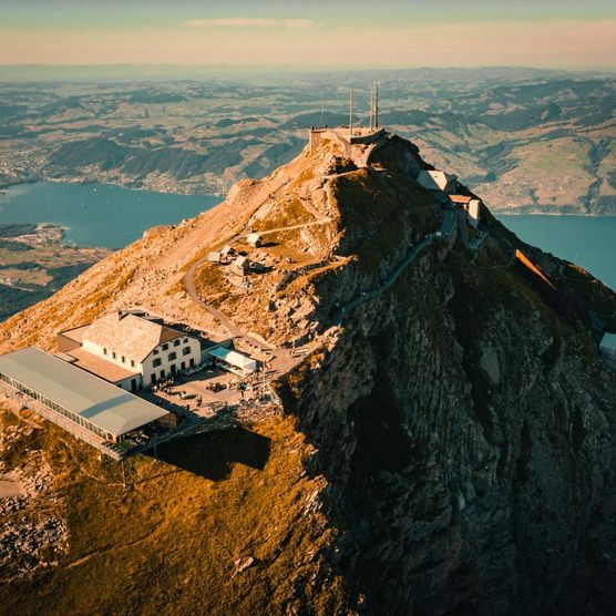 Die Luftaufnahme zeigt die Bergstation und das Gasthaus auf dem Niesen. Im Hintergrund ist der Thunersee zusehen.