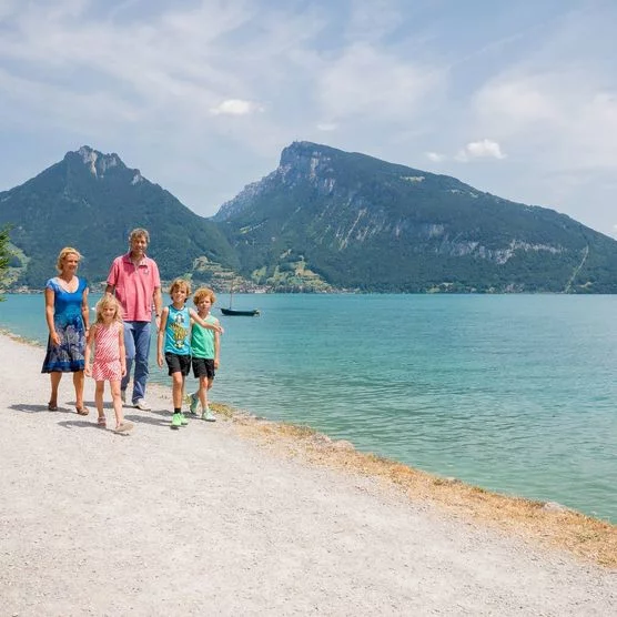 Familie spaziert entlang des Thunersees auf dem Strandweg von Spiez nach Faulensee