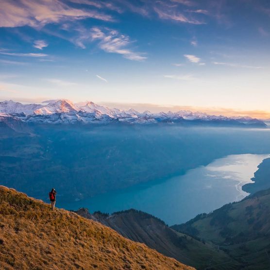 Wanderer blickt über den Brienzersee und geniesst die Abendstimmung