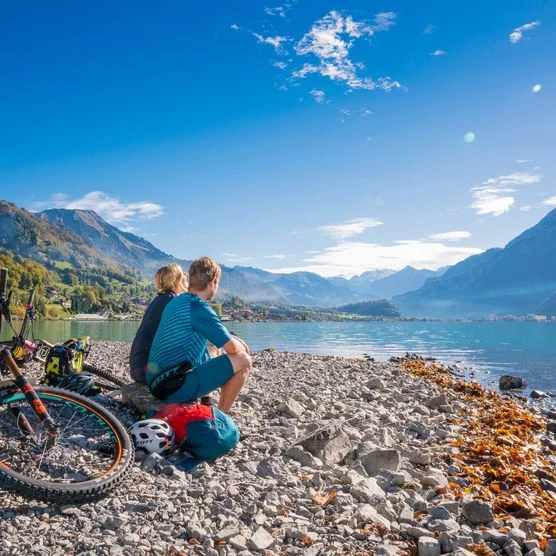 Paar mit Bikes machen Pause in Brienz am türkisfarbenen Brienzersee