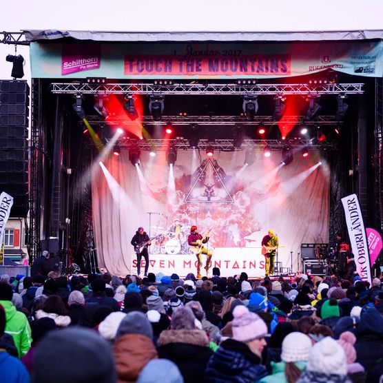 Beleuchtete Bühne mit Musiker und Zuschauer am Touch the Mountains in Interlaken